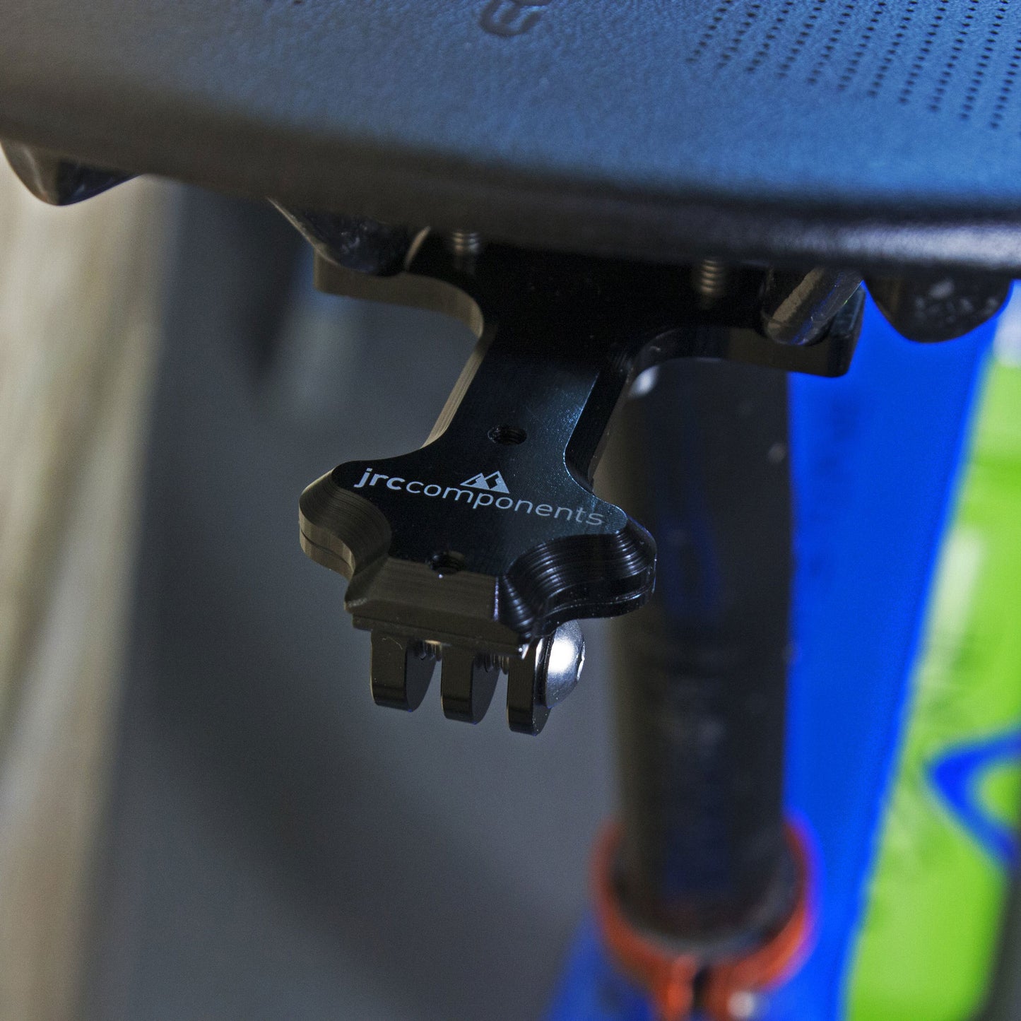 Black saddle rail mount with adaptor piece for rear lights and action cameras, fitted to saddle rail, overview.